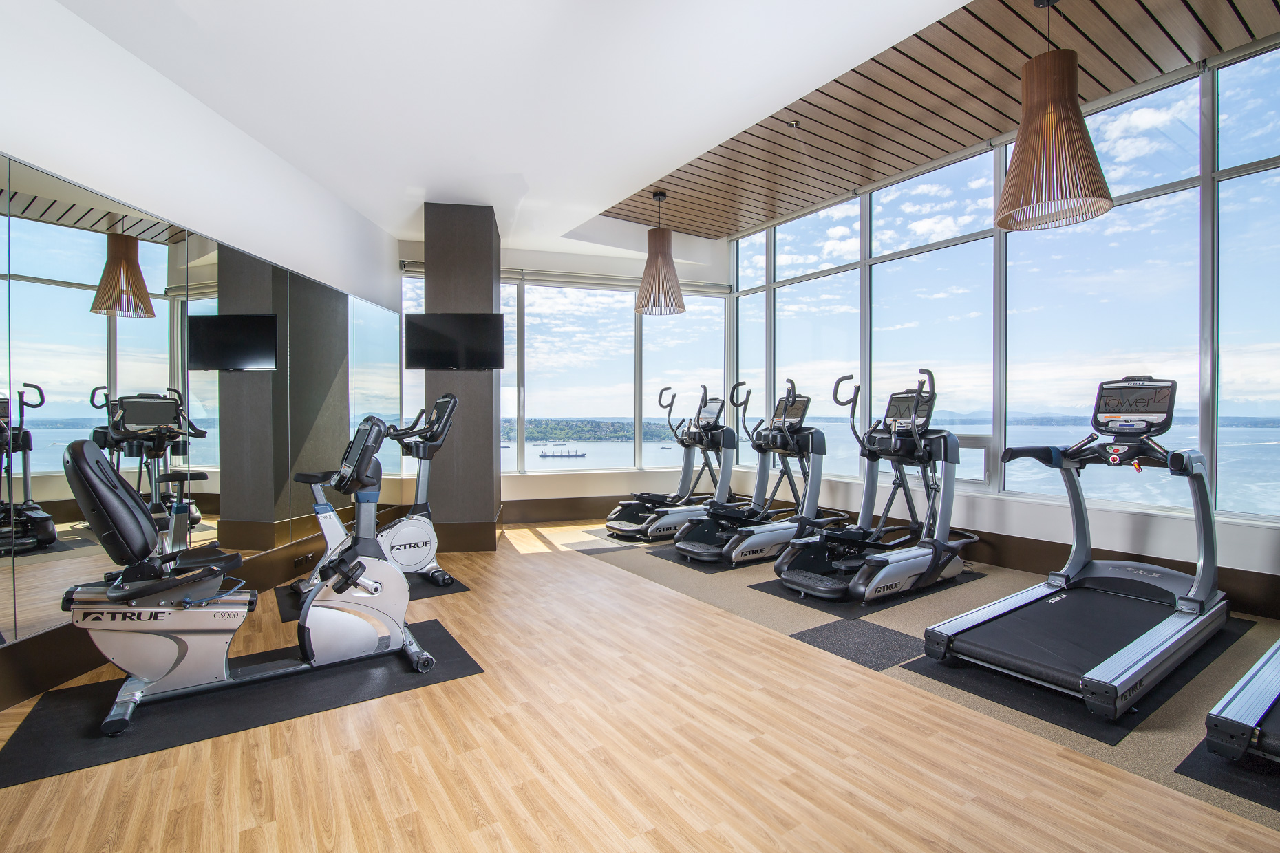 Private gym with water views and hardwood floors